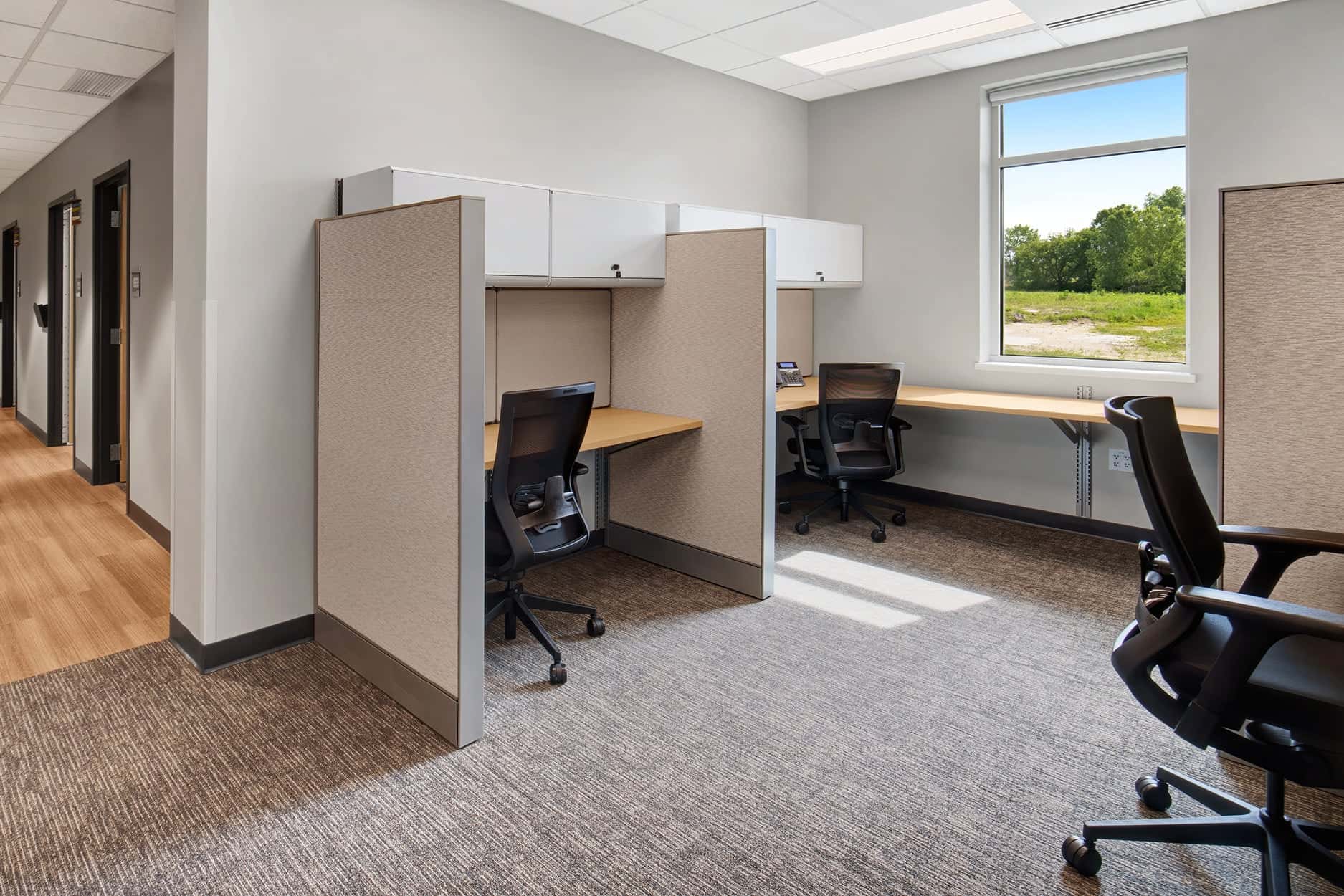 Ergonomic mesh task chairs at paneled clinical workstations in a healthcare administrative office