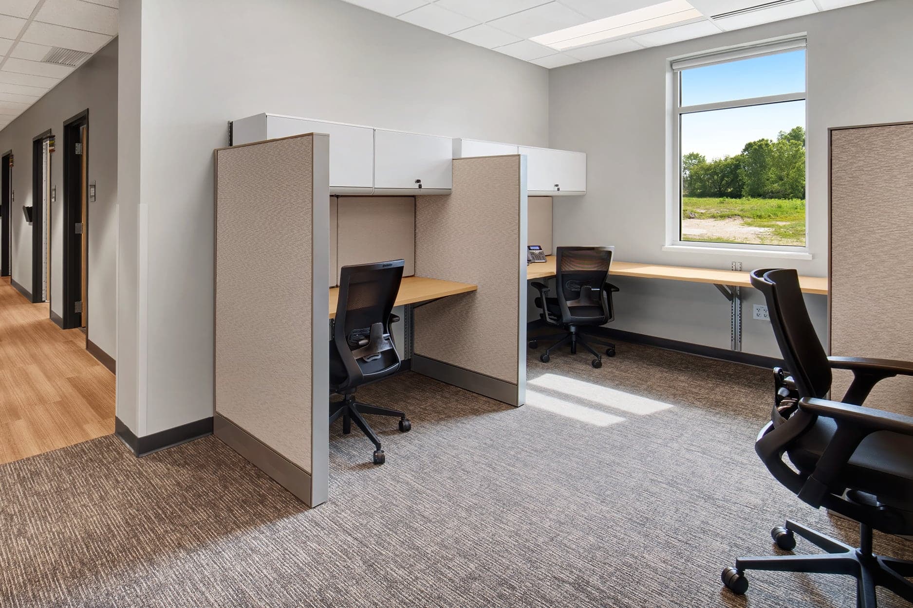 Ergonomic mesh task chairs at paneled clinical workstations in a healthcare administrative office