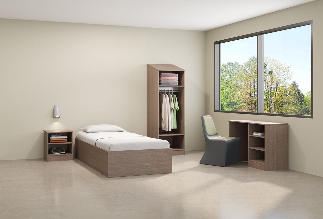 Calm, residential-feeling behavioral health environment furnished with ligature-resistant seating and casegoods