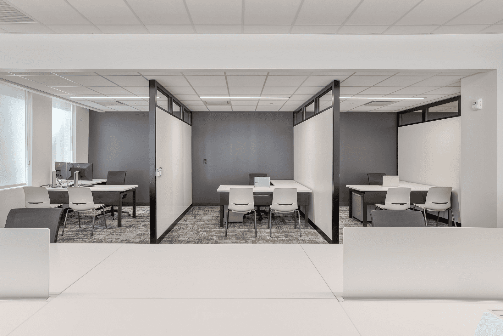 Office layout blending open bench workstations with semi-enclosed private meeting rooms