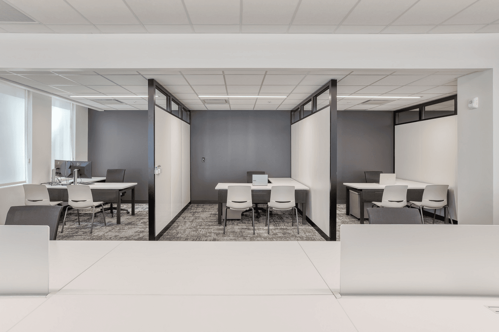 Office layout blending open bench workstations with semi-enclosed private meeting rooms