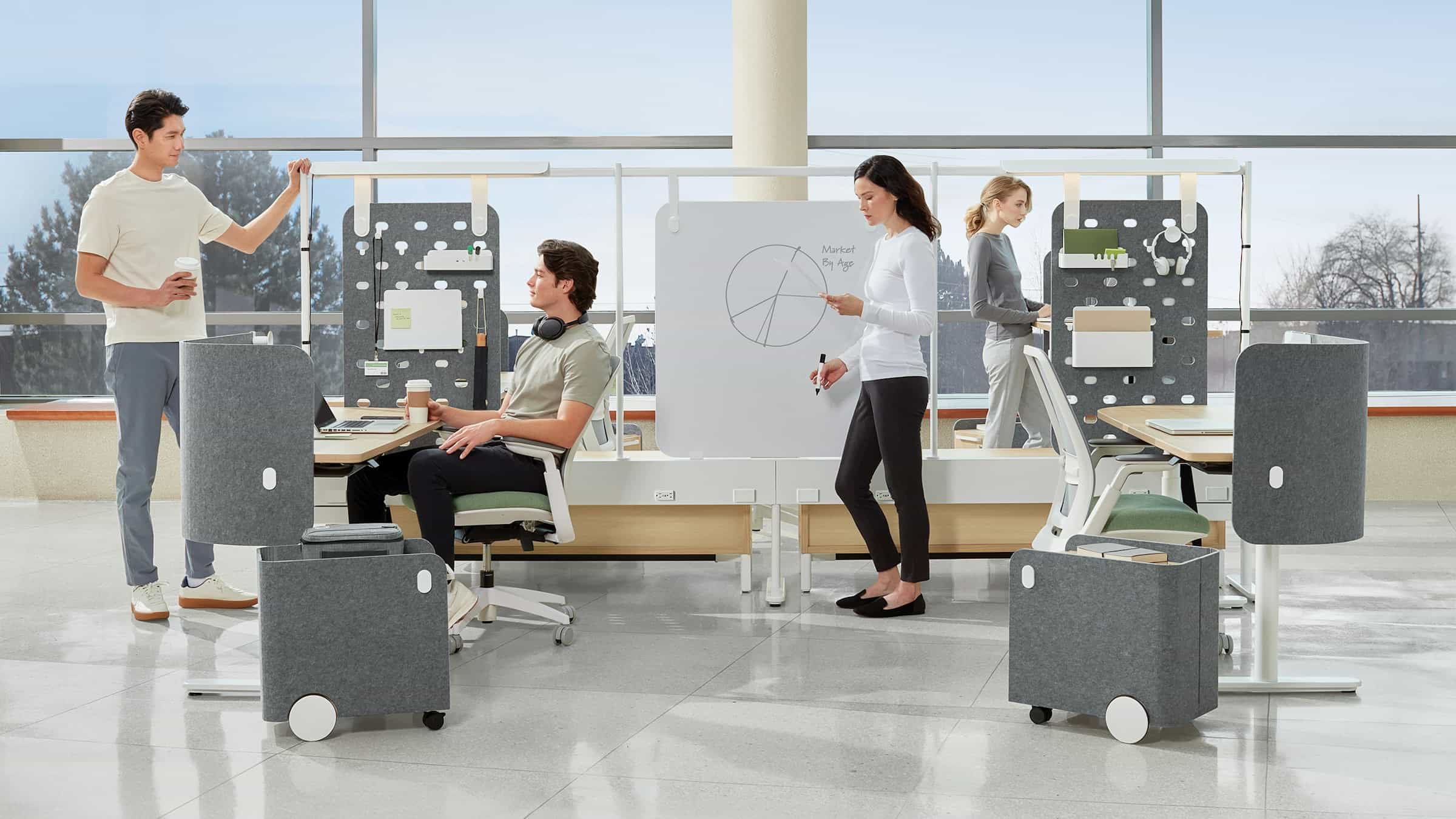 Open-plan administrative office with height-adjustable workstations and acoustic screens