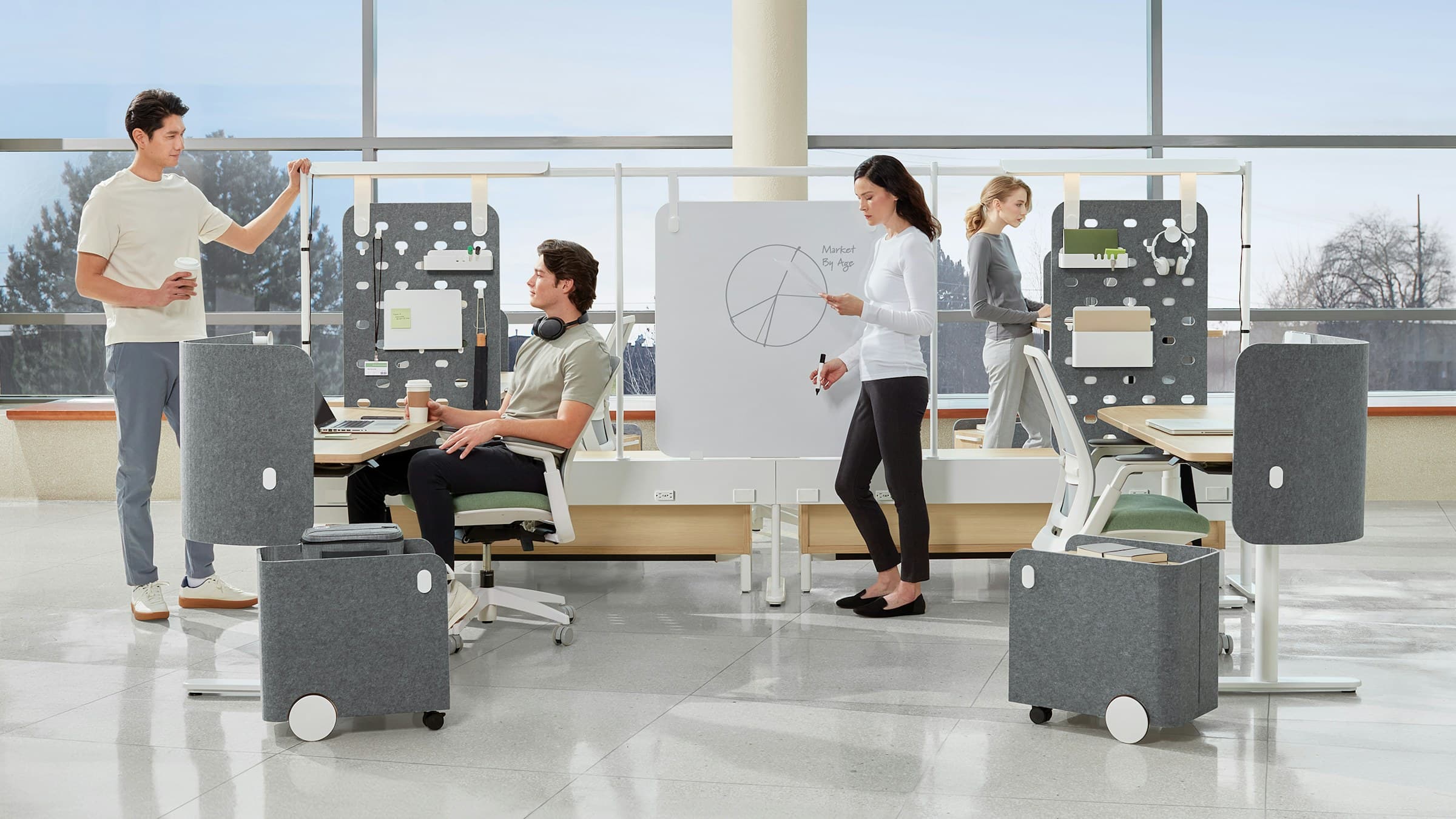 Open-plan administrative office with height-adjustable workstations and acoustic screens