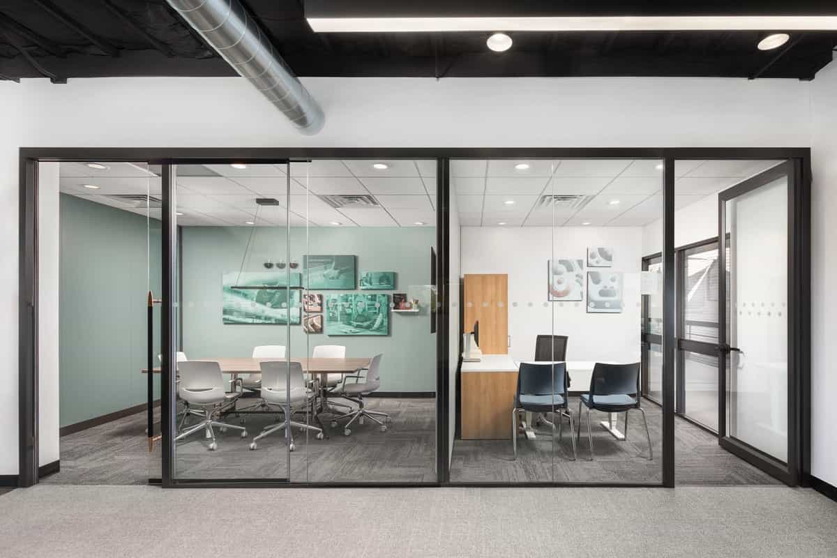 Modern office with full-height demountable glass walls creating private conference rooms in Florida