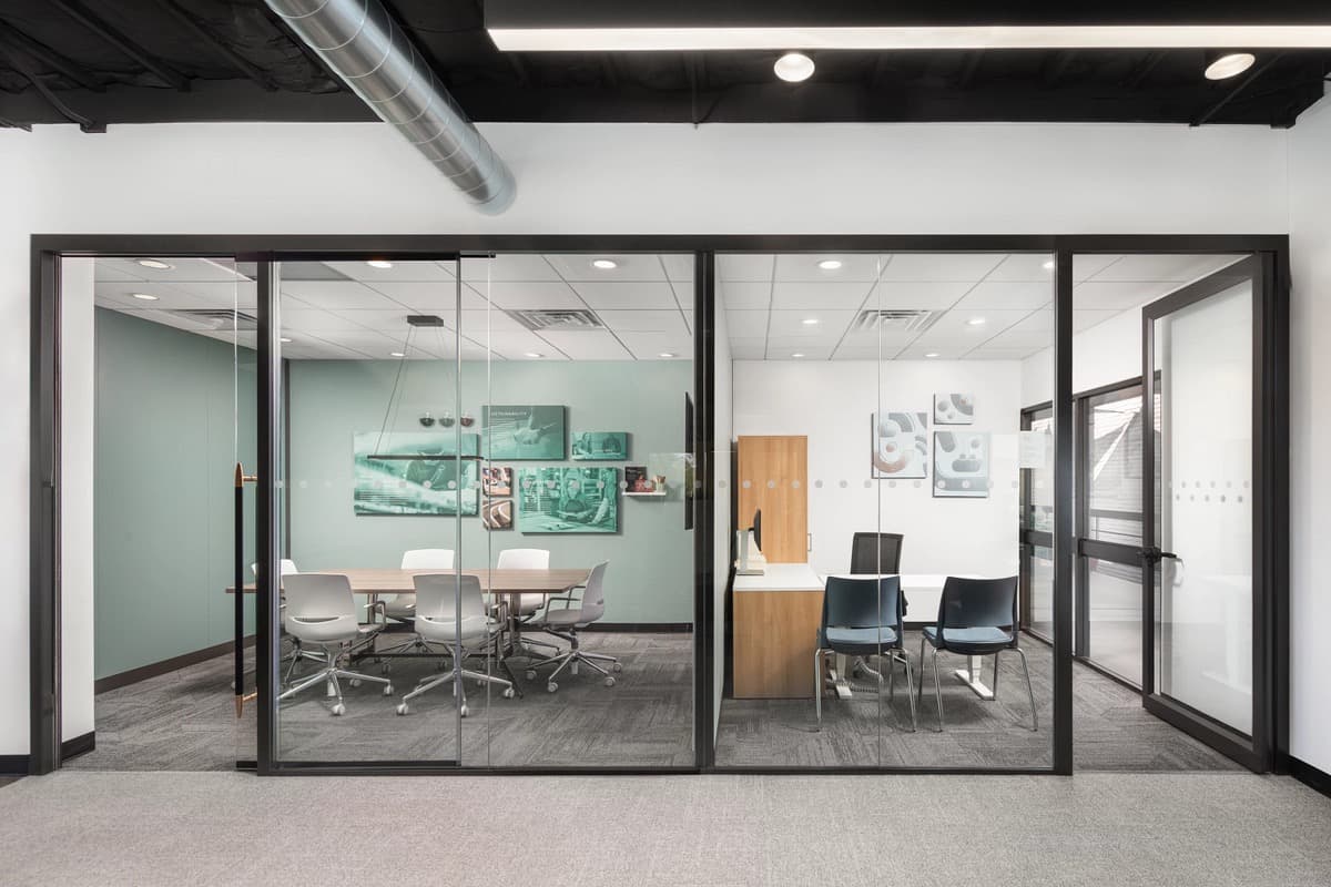 Modern office with full-height demountable glass walls creating private conference rooms in Florida
